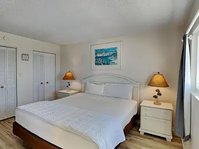 a bedroom with a white bed and two night stands at Regency Towers Panama City Beach #719 in Panama City Beach