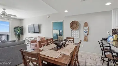 a living room with a table and chairs at Sterling Breeze 1007 in Panama City Beach