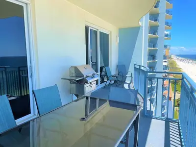 a balcony with a glass table and chairs on it at Sterling Breeze 1007 in Panama City Beach