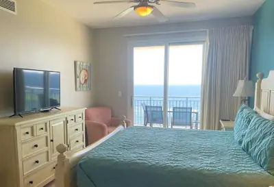 a bedroom with a bed and a flat screen tv at Sterling Breeze 1007 in Panama City Beach