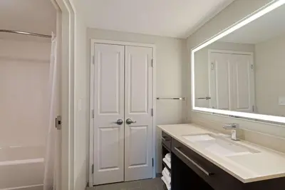 a white bathroom with a sink and a mirror at Homewood Suites By Hilton Panama City Beach, Fl in Panama City Beach