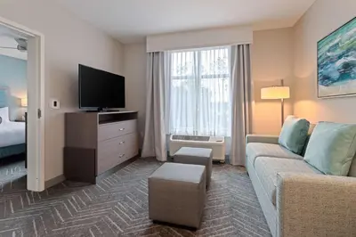 a living room with a couch and a tv at Homewood Suites By Hilton Panama City Beach, Fl in Panama City Beach