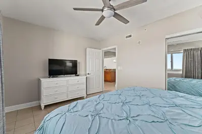 a bedroom with a bed and a flat screen tv at Emerald Beach #1330 by Book That Condo in Panama City Beach