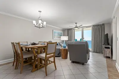 a dining room and living room with a table and chairs at Emerald Beach #1330 by Book That Condo in Panama City Beach