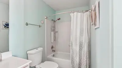 a bathroom with a white toilet and a shower curtain at Ocean Villa 305 by Sand Seeker Vacations in Panama City Beach