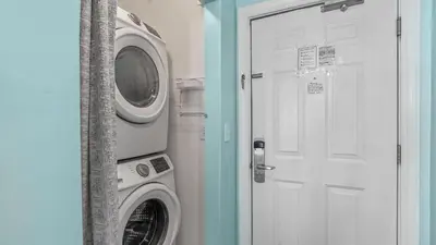 a washing machine sitting next to a white door at Ocean Villa 305 by Sand Seeker Vacations in Panama City Beach