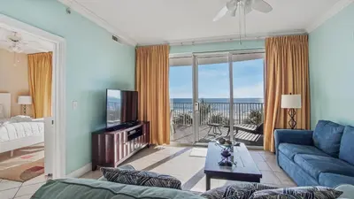 a living room with a blue couch and a television at Ocean Villa 305 by Sand Seeker Vacations in Panama City Beach