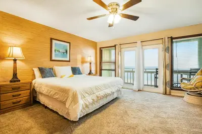 a bedroom with a bed and a ceiling fan at The Shell Shack #3 by Sand Seeker Vacations in Panama City Beach