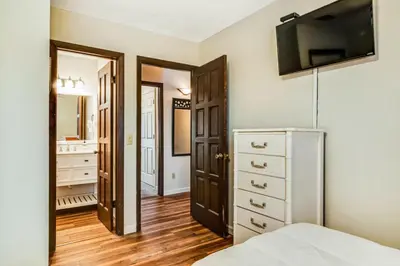 a bedroom with a bed and a tv on the wall at The Shell Shack #3 by Sand Seeker Vacations in Panama City Beach