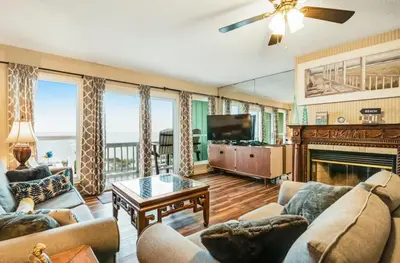 a living room with a couch and a fireplace at The Shell Shack #3 by Sand Seeker Vacations in Panama City Beach