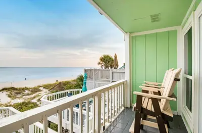a rocking chair on a balcony overlooking the beach at The Shell Shack #3 by Sand Seeker Vacations in Panama City Beach