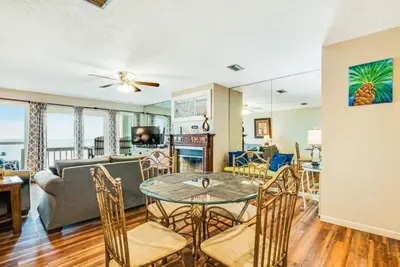 a living room with a table and chairs and a couch at The Shell Shack #3 by Sand Seeker Vacations in Panama City Beach