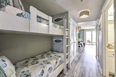 a small bedroom with a bed and a dining room at Panama City Beach Condo with Free Beach Service! in Panama City Beach