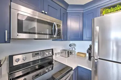 a kitchen with blue cabinets and a stainless steel refrigerator at Panama City Beach Condo with Free Beach Service! in Panama City Beach