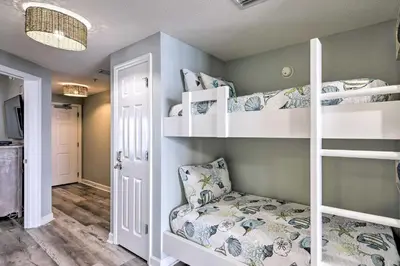 a room with three bunk beds and a couch at Panama City Beach Condo with Free Beach Service! in Panama City Beach