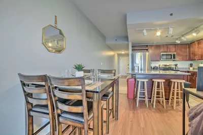 a kitchen with a table and some bar stools at Lagoon-View Balcony! Family Resort Escape in PCB in Panama City Beach