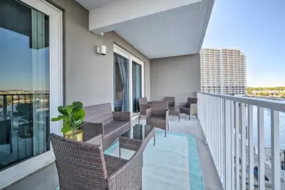 a balcony with chairs and a table and a pool at Lagoon-View Balcony! Family Resort Escape in PCB in Panama City Beach