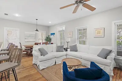 a living room with white furniture and a ceiling fan at Beach Bungalow, 3 Min Walk to Beach, Golf Cart, 4 bikes, Wagon in Seacrest