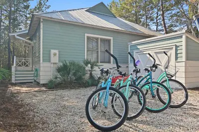a group of bikes parked in front of a house at Beach Bungalow, 3 Min Walk to Beach, Golf Cart, 4 bikes, Wagon in Seacrest
