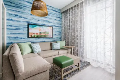 a living room with a couch and a blue wall at Hyatt Place Panama City Beach - Beachfront in Panama City Beach