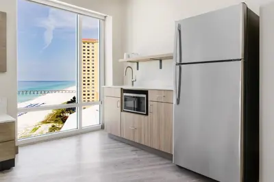a kitchen with a refrigerator and a view of the beach at Hyatt Place Panama City Beach - Beachfront in Panama City Beach