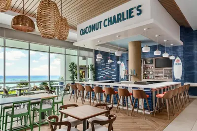a restaurant with a bar with chairs and tables at Hyatt Place Panama City Beach - Beachfront in Panama City Beach