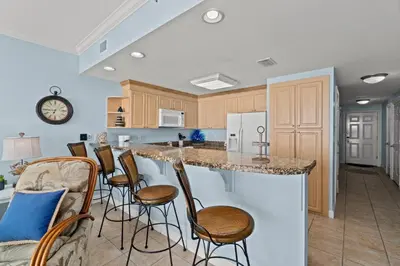 a kitchen with a large island with bar stools at Boardwalk Beach Resort #1403 by Book That Condo in Panama City Beach