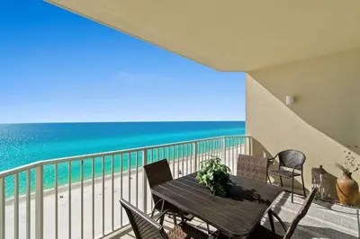 a table on a balcony with a view of the beach at Boardwalk Beach Resort #1403 by Book That Condo in Panama City Beach