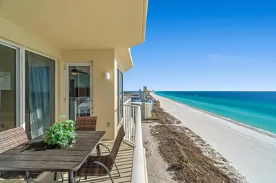 a balcony with a table and chairs and the beach at Boardwalk Beach Resort #1403 by Book That Condo in Panama City Beach