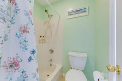 a bathroom with a toilet and a shower curtain at Cozy PCB Condo Less Than half Mile to Public Beach Access! in Panama City Beach