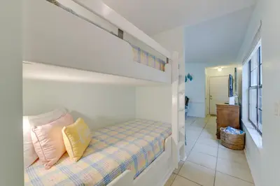 a bedroom with a bunk bed with yellow pillows at Cozy PCB Condo Less Than half Mile to Public Beach Access! in Panama City Beach