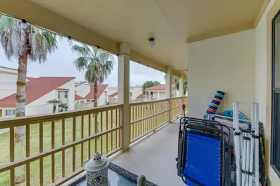 a balcony with a view of a house at Cozy PCB Condo Less Than half Mile to Public Beach Access! in Panama City Beach