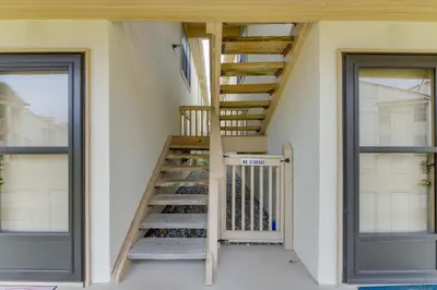 a staircase in a house with two windows at Cozy PCB Condo Less Than half Mile to Public Beach Access! in Panama City Beach