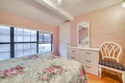 a bedroom with a bed and a dresser and a mirror at Panama City Beach Townhome - Walk to Beach! in Panama City Beach