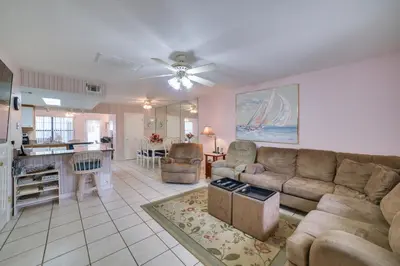 a living room with a couch and a kitchen at Panama City Beach Townhome - Walk to Beach! in Panama City Beach