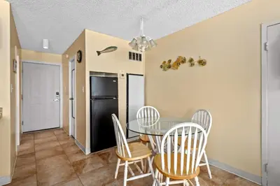 a kitchen and dining room with a table and chairs at Top Of The Gulf 621 in Panama City Beach