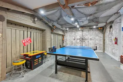 a ping pong table in a garage with a sign at Top Of The Gulf 621 in Panama City Beach