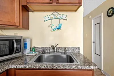 a kitchen with a sink and a microwave at Top Of The Gulf 621 in Panama City Beach