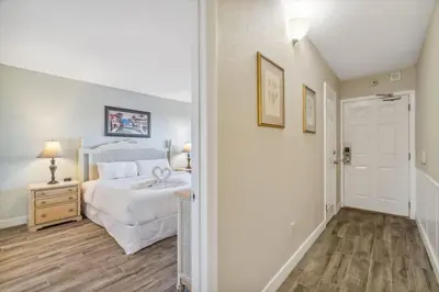 a bedroom with a white bed and a wooden floor at The Summit 108 in Panama City Beach