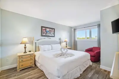 a bedroom with a large white bed and a red chair at The Summit 108 in Panama City Beach