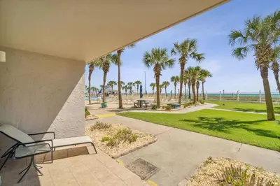 a patio with a view of the beach and palm trees at The Summit 108 in Panama City Beach