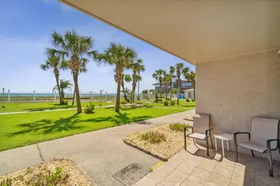 a patio with a view of the ocean and palm trees at The Summit 108 in Panama City Beach