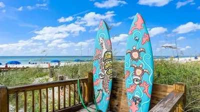 two surfboards leaned up against a fence at the beach at The Summit 108 in Panama City Beach