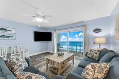 a living room with a couch and a tv at The Summit 1031 in Panama City Beach