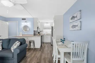 a living room and kitchen with a couch and a table at The Summit 1031 in Panama City Beach