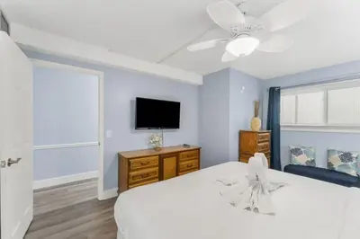 a bedroom with a bed and a flat screen tv at The Summit 1031 in Panama City Beach