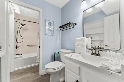 a white bathroom with a toilet and a sink at The Summit 1031 in Panama City Beach