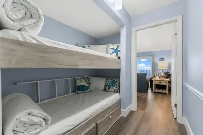 a bedroom with two bunk beds and a living room at The Summit 1031 in Panama City Beach