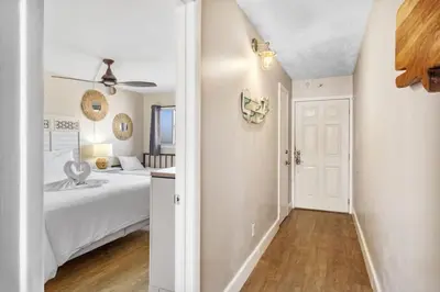 a white bedroom with a bed and a bathroom at The Summit 1322 in Panama City Beach