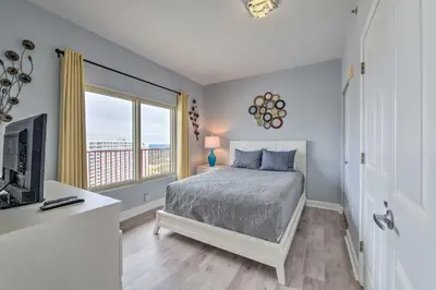 a bedroom with a bed and a large window at Oceanfront PCB Resort Condo with Balcony and Views! in Panama City Beach